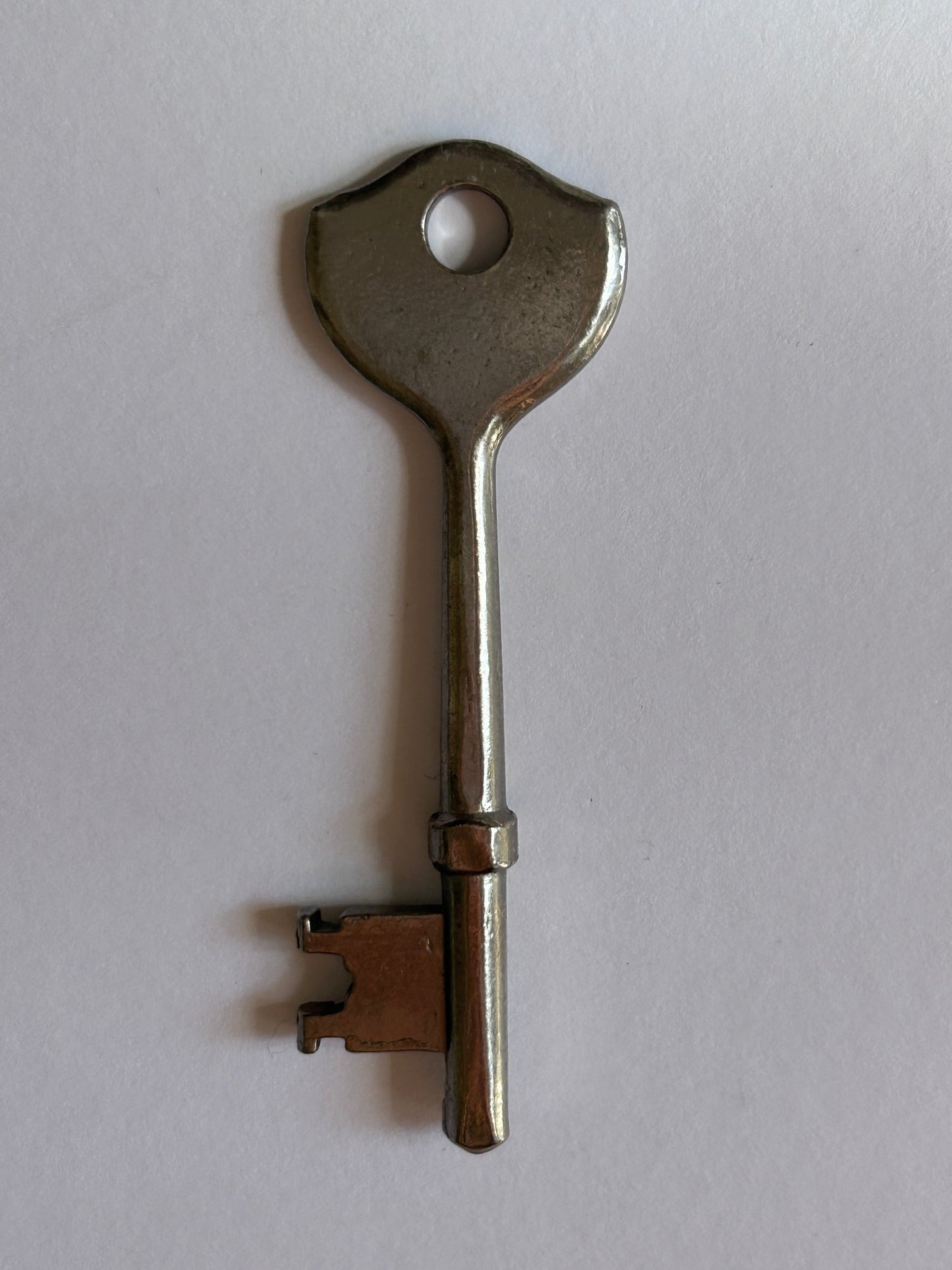 Metal key on a light gray background